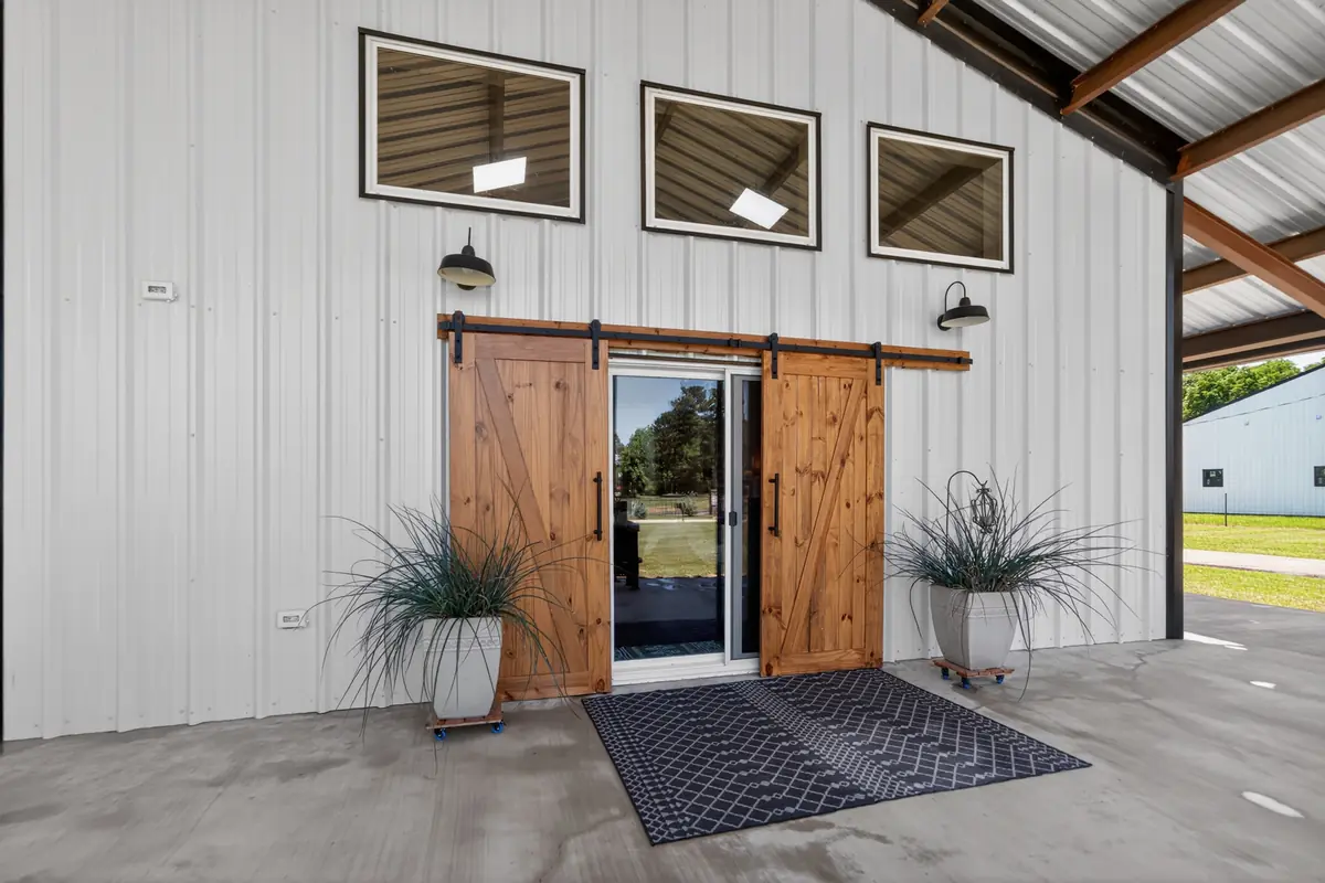 Exterior barn doors with black hardware and coach lights, brand new 2024 barndominium Chandler TX