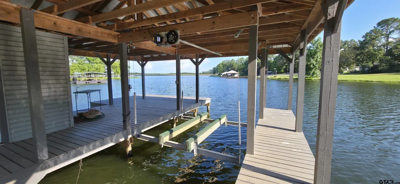 Covered boat slip with an electric lift and a deck inside the boathouse at 644 An County Road 3009 on Lake Palestine in Frankston TX