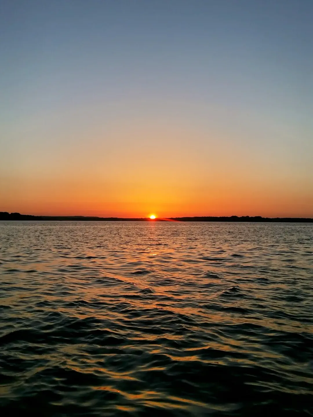 Golden sunset over Lake Palestine East Texas reflected on calm water