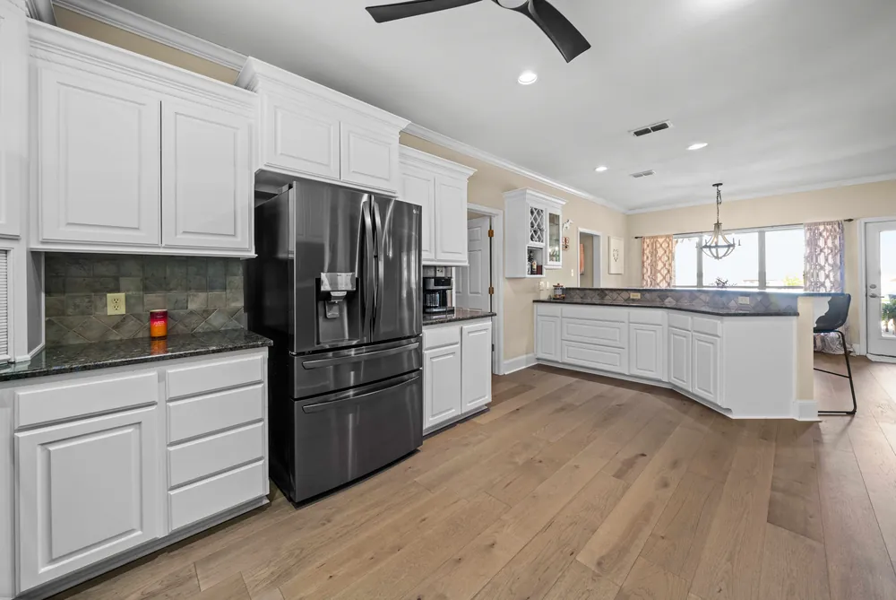 Gourmet kitchen with white cabinets granite countertops and hardwood floors at this Lake Palestine waterfront home in Chandler TX for sale