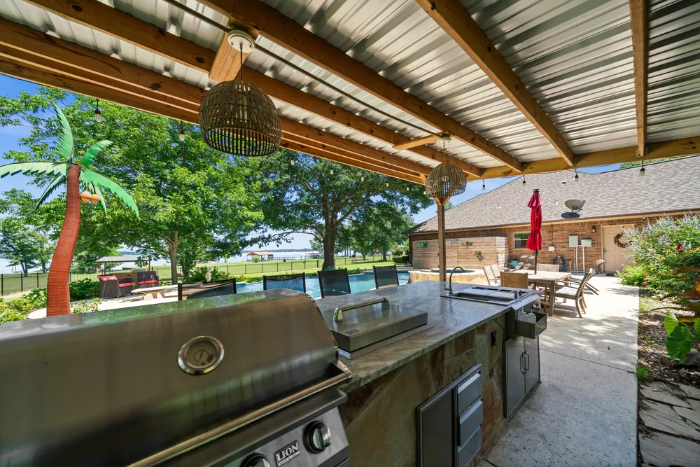 Covered outdoor kitchen with Lion grill granite counters and lake views at Sunrise Shores Lake Palestine Chandler TX