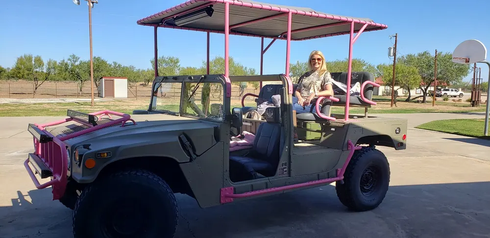 Charlene Hall, East TX Realtor®, riding in a pink Humvee at Triple T Ranch in Encinal Texas